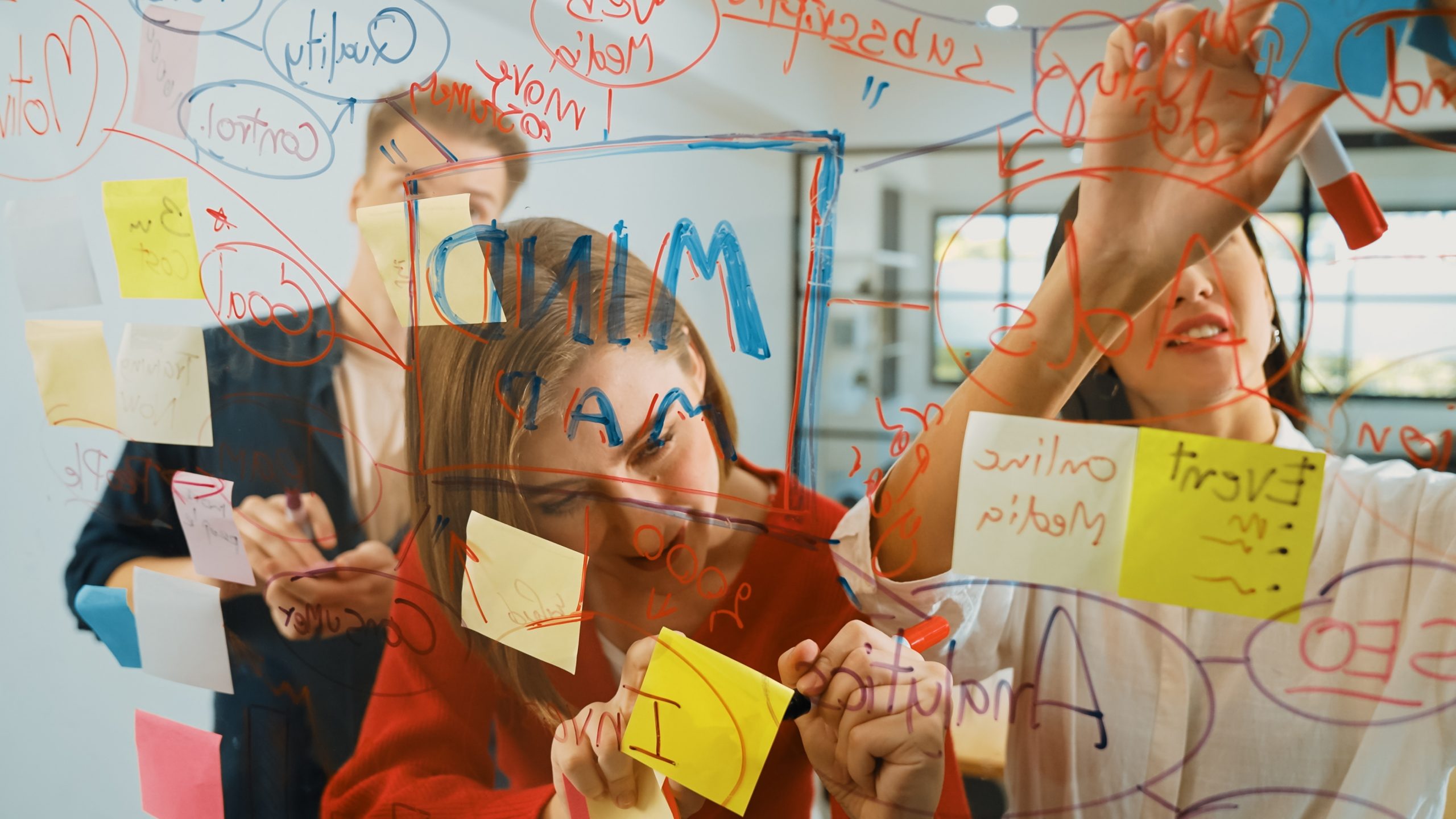 Creative business team sharing idea, writing down on sticky note. Immaculate.